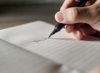 미국 학교에서 필기체 쓰기가 다시 주목받는 이유 a person writing on a piece of paper with a pen