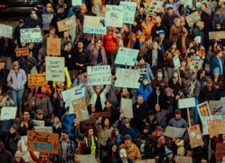 ICE 최대 구금시설 실태 폭로 Crowd of people holding signs at a protest