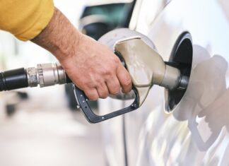 세금 환급금 유가 상승으로 상쇄된다, NC 한인 운전자들이 알아야 할 현실 a man pumping gas into his car at a gas station
