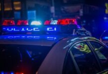 애쉬빌 강력범죄 감소, 5년 넘는 기간 중 최저 수준 A police car with flashing red and blue emergency lights on a city street
