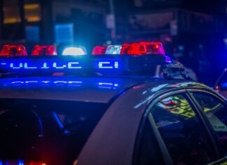 애쉬빌 강력범죄 감소, 5년 넘는 기간 중 최저 수준 A police car with flashing red and blue emergency lights on a city street