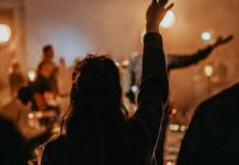 청년 교회 출석 늘었다, 기도가 첫째 이유라는 조사 결과 예배당에서 함께 기도하는 청년들, 청년 교회 출석 증가 조사